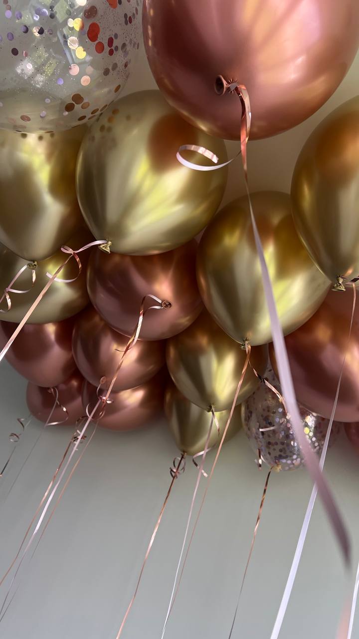 Gold and rose gold helium ceiling balloons with ribbons in New York City