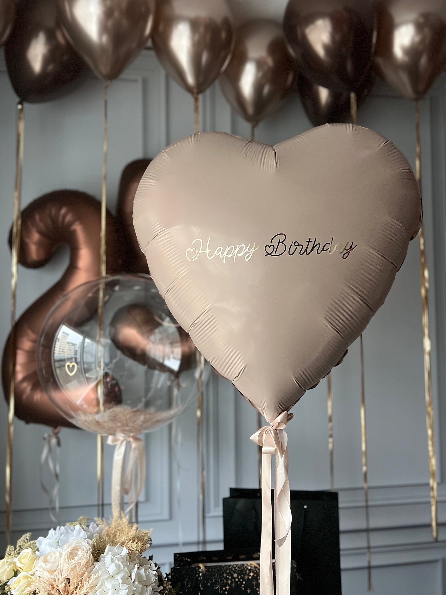 Bronze milestone balloon decor with heart balloon, feather bubble balloon, and number balloons in Manhattan
