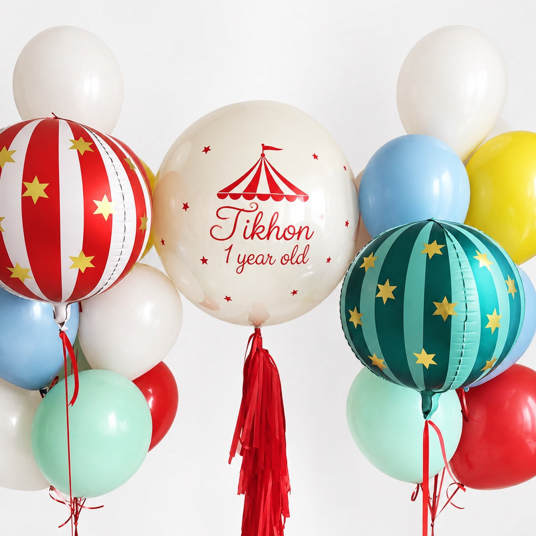 Circus birthday balloon set with two bunches of 10 colorful latex balloons, two striped star-patterned sphere balloons, and one personalized bubble balloon.