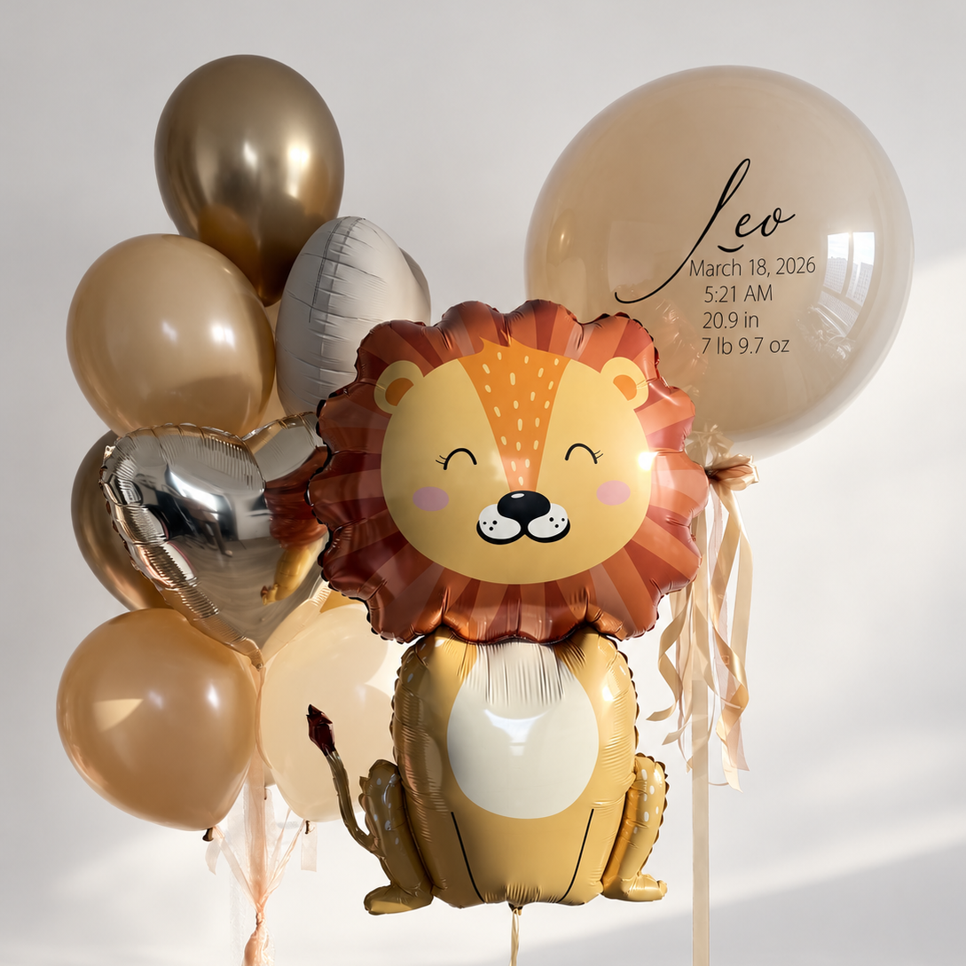 Smiling lion balloon beside a personalized cream bubble balloon and a bunch of cream and gold latex balloons with silver foil hearts.