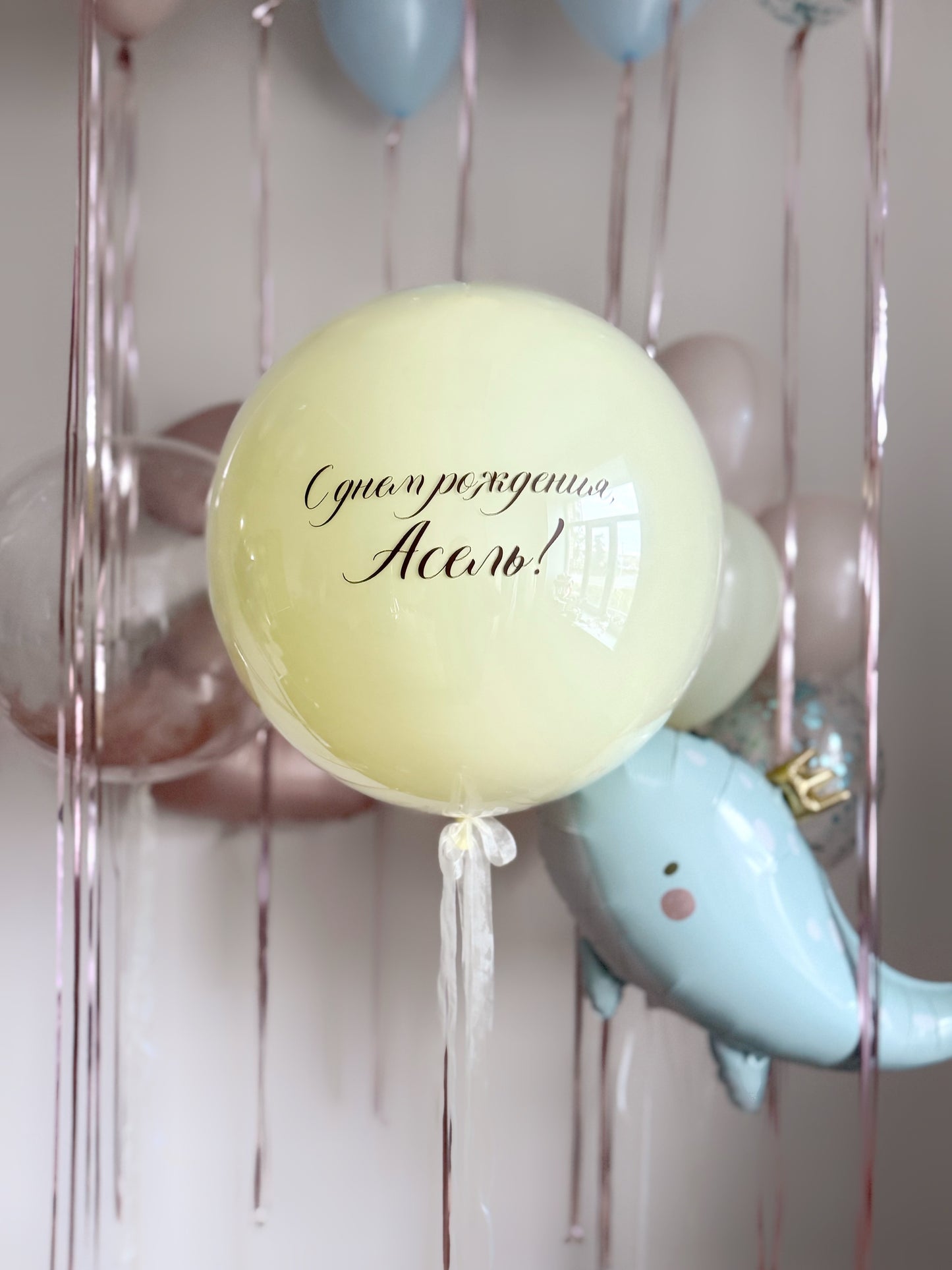 Close-up of pastel bubble balloon with custom sign and blue whale balloon for kids party decor in Brooklyn