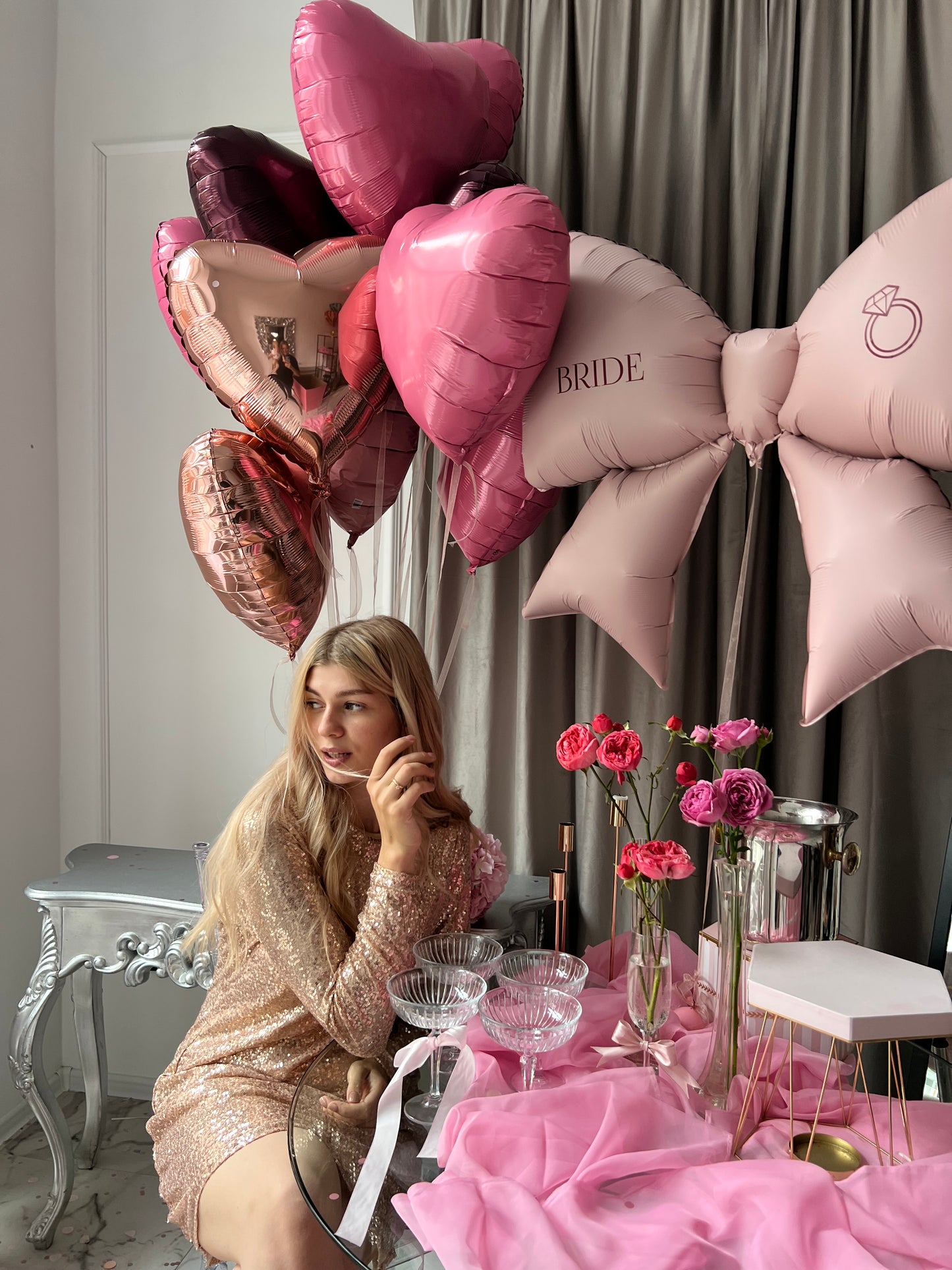 Close-up of raspberry bow balloon with custom sign and heart balloons for bachelorette party decor in Brooklyn