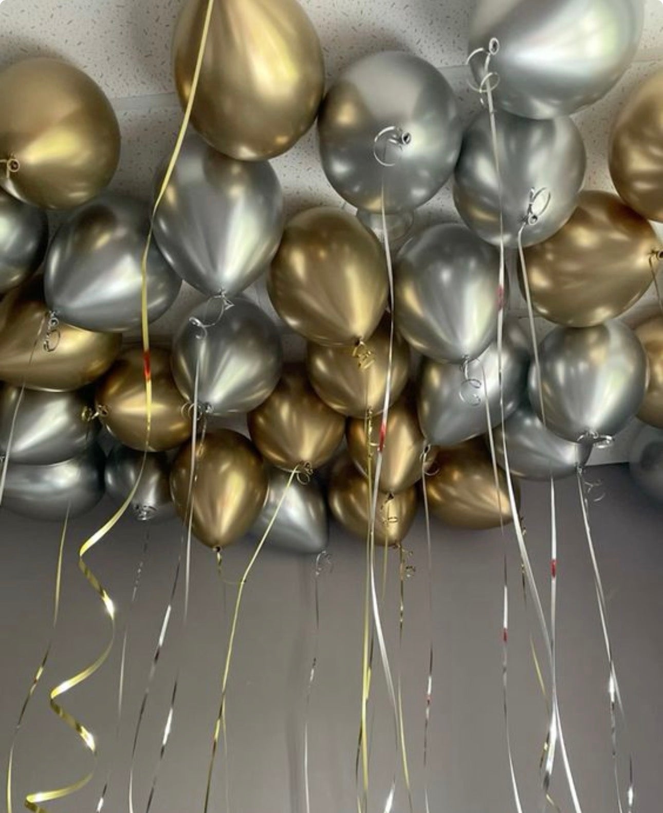 Gold and silver reflex helium ceiling balloons with metallic ribbons for event decor in NYC