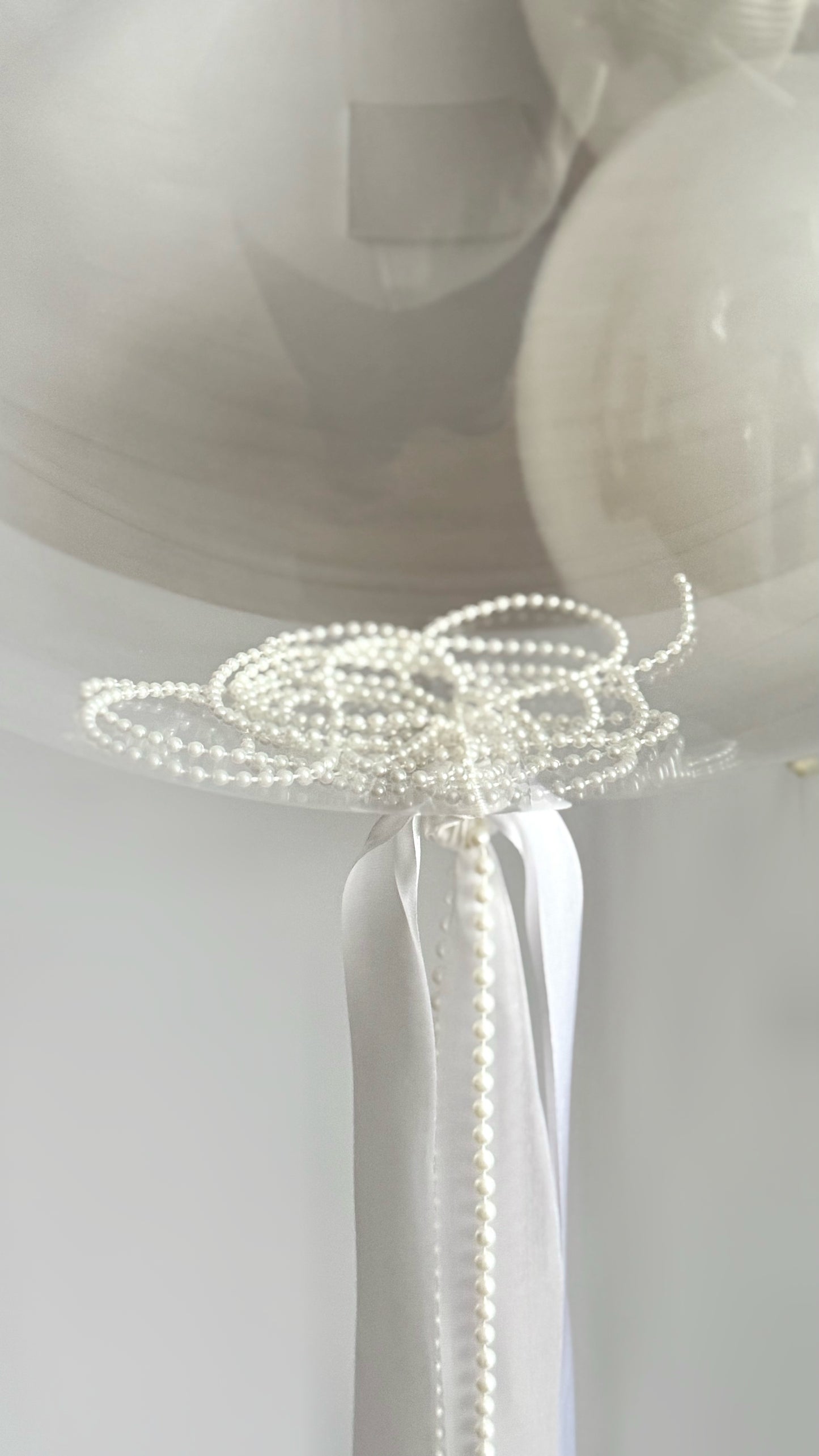 Close-up of clear bubble balloon knot and ribbon styling for bridal event decor in NYC