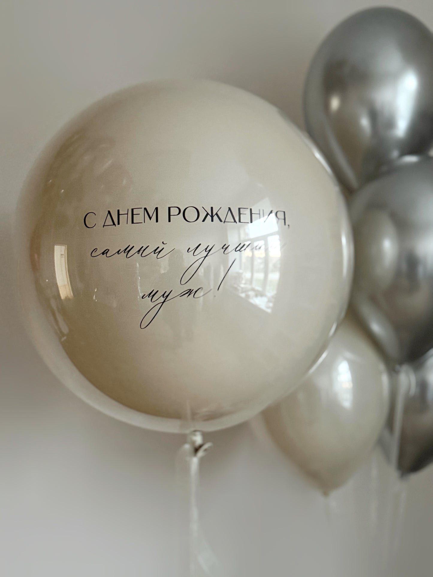 Close-up of pearl double bubble balloon with custom sign and silver balloons for celebration decor in NYC
