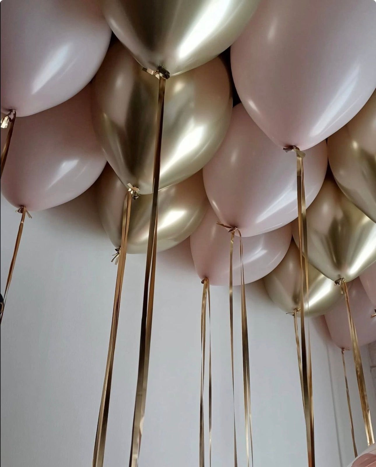 Luxury gold and pink helium ceiling balloons in NYC designed to create a soft yet elegant atmosphere for bridal events and special celebrations.