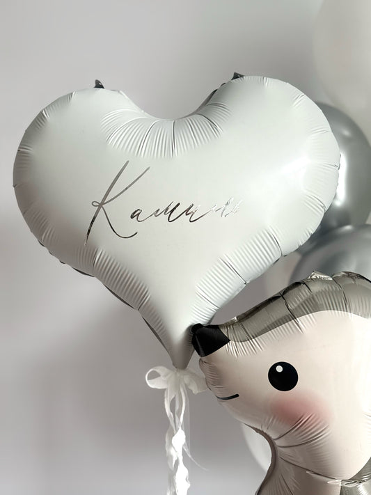 Close-up of white heart balloon with custom sign and silver bunny balloon for celebration decor in NYC
