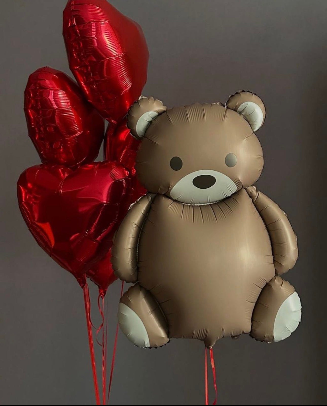 Teddy bear balloon with floating red heart balloons for romantic surprise decor in Brooklyn