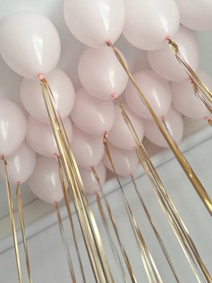 Close-up of blush latex balloons and ribbon styling for gender reveal balloon box in NYC
