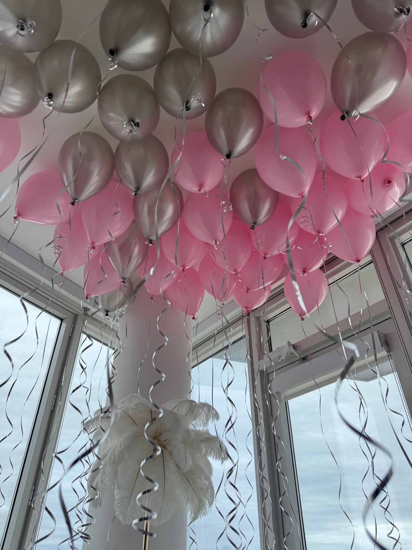 Pink and silver helium ceiling balloons with ribbons in New York City
