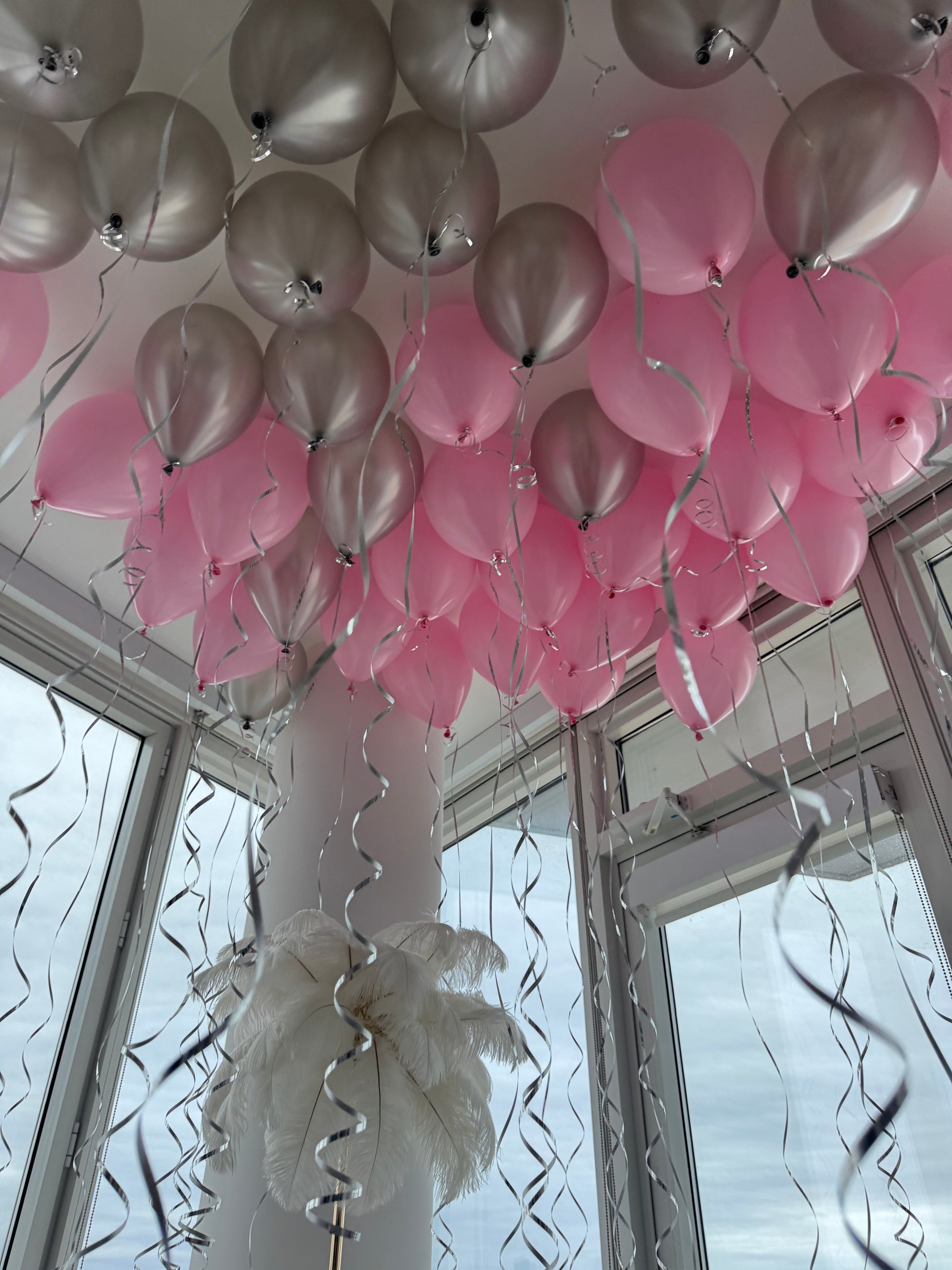 Pink and silver helium ceiling balloons with ribbons in New York City
