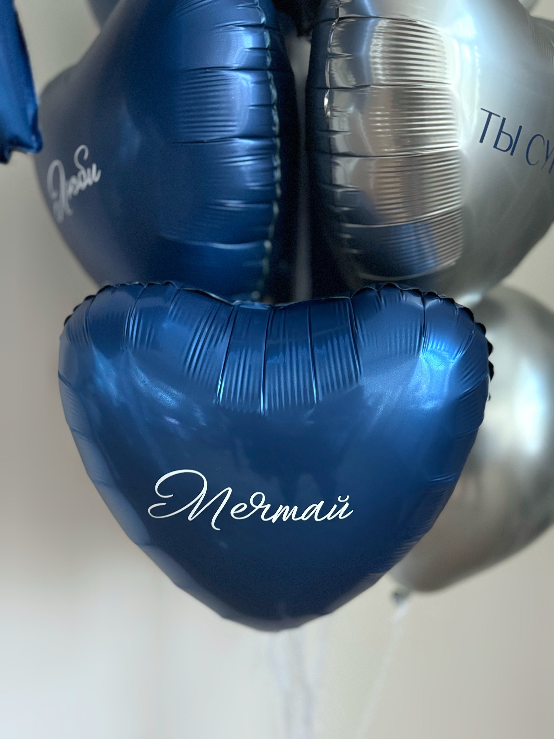 Close-up of blue heart balloon with custom sign and metallic balloon styling in NYC