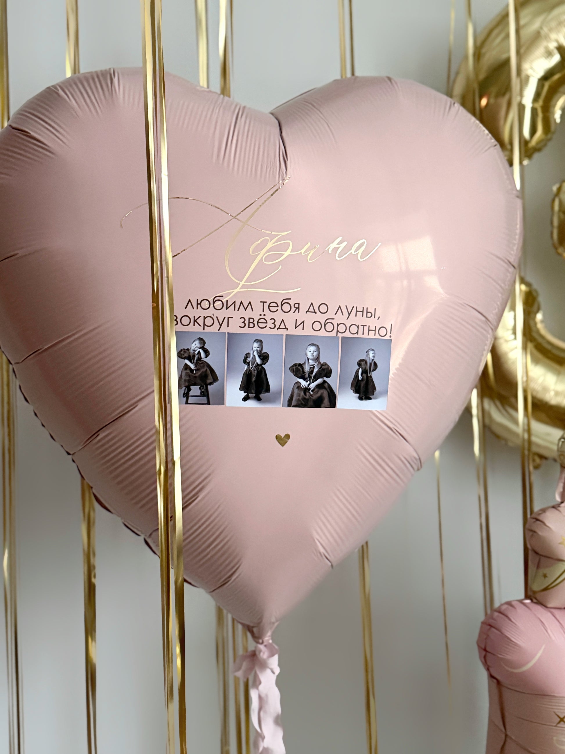 Close-up of pink heart balloon with custom photos for birthday party decor in NYC
