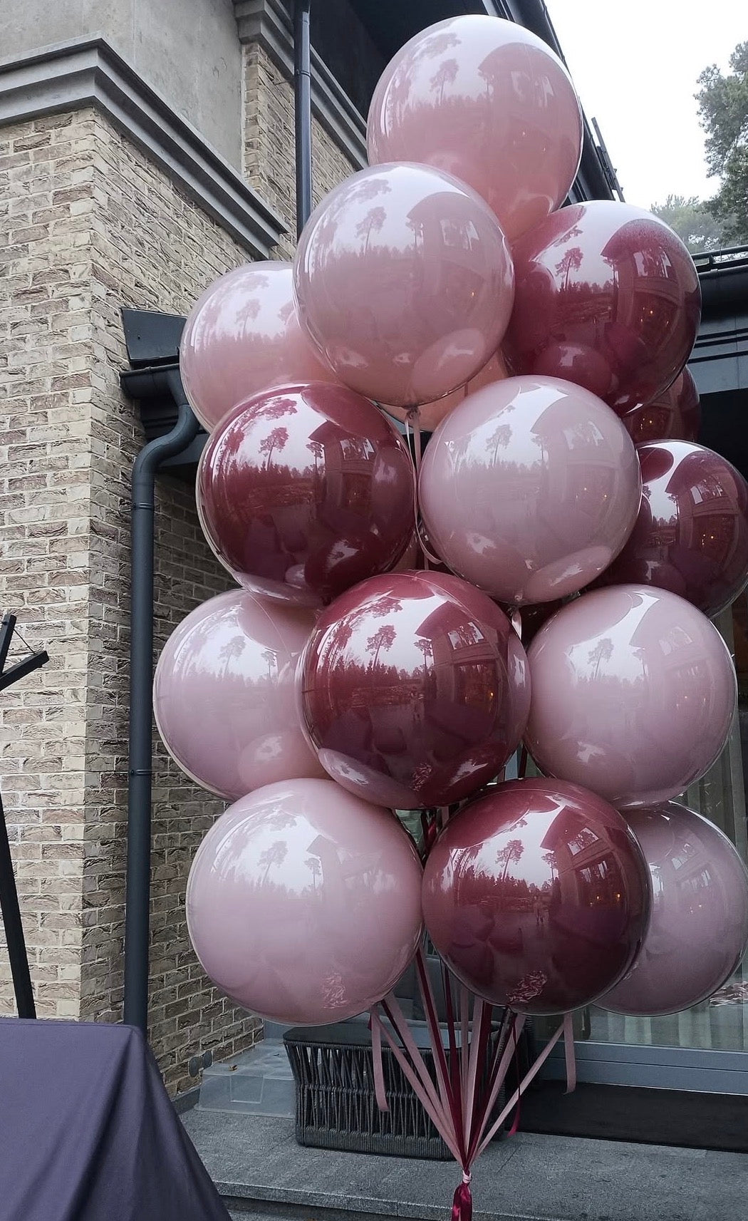 Large double bubble balloon bouquet in blush and burgundy tones for event decor in New York