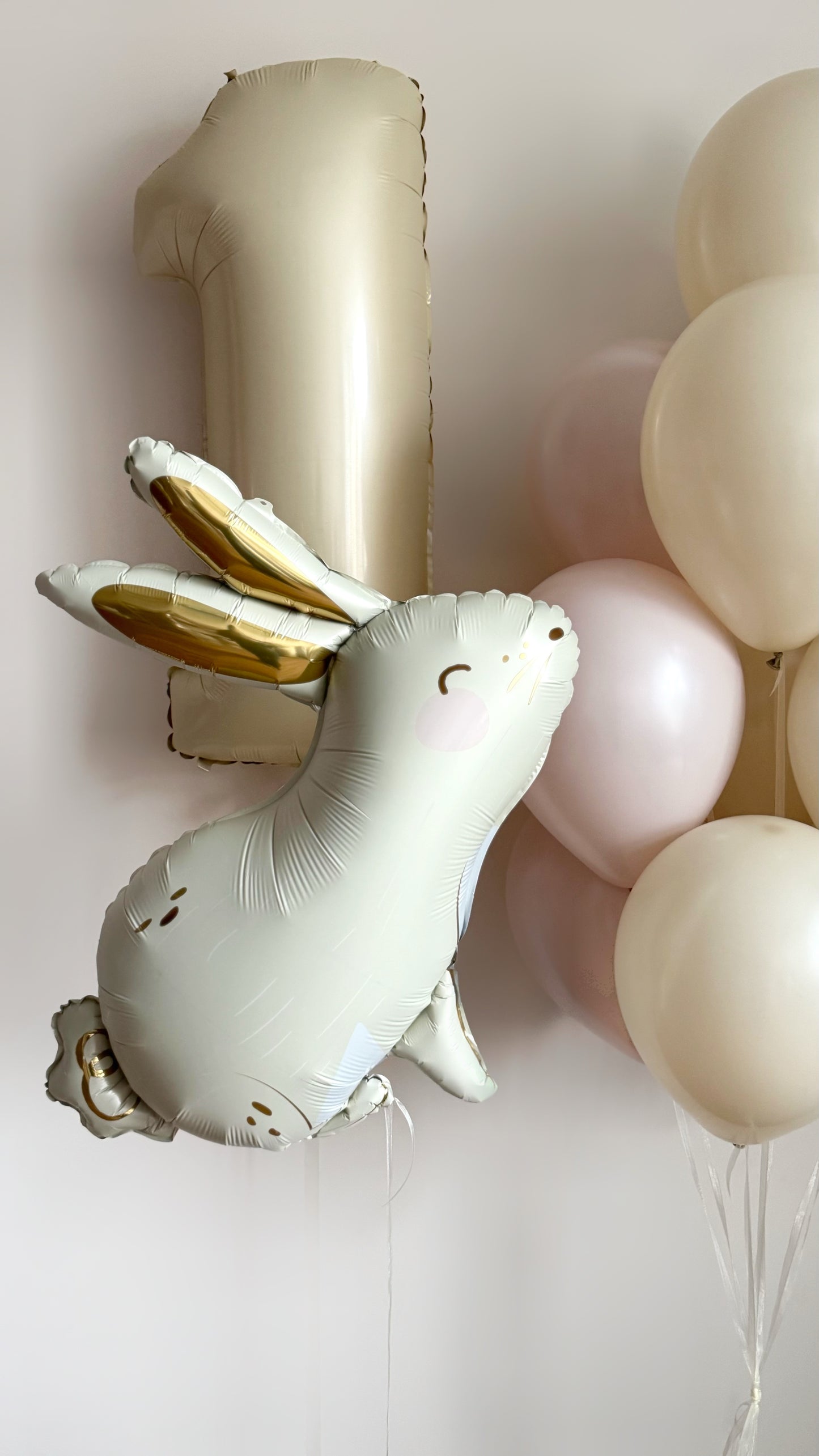 Close-up of blush bunny balloon with pastel latex balloons for kids party decor in NYC
