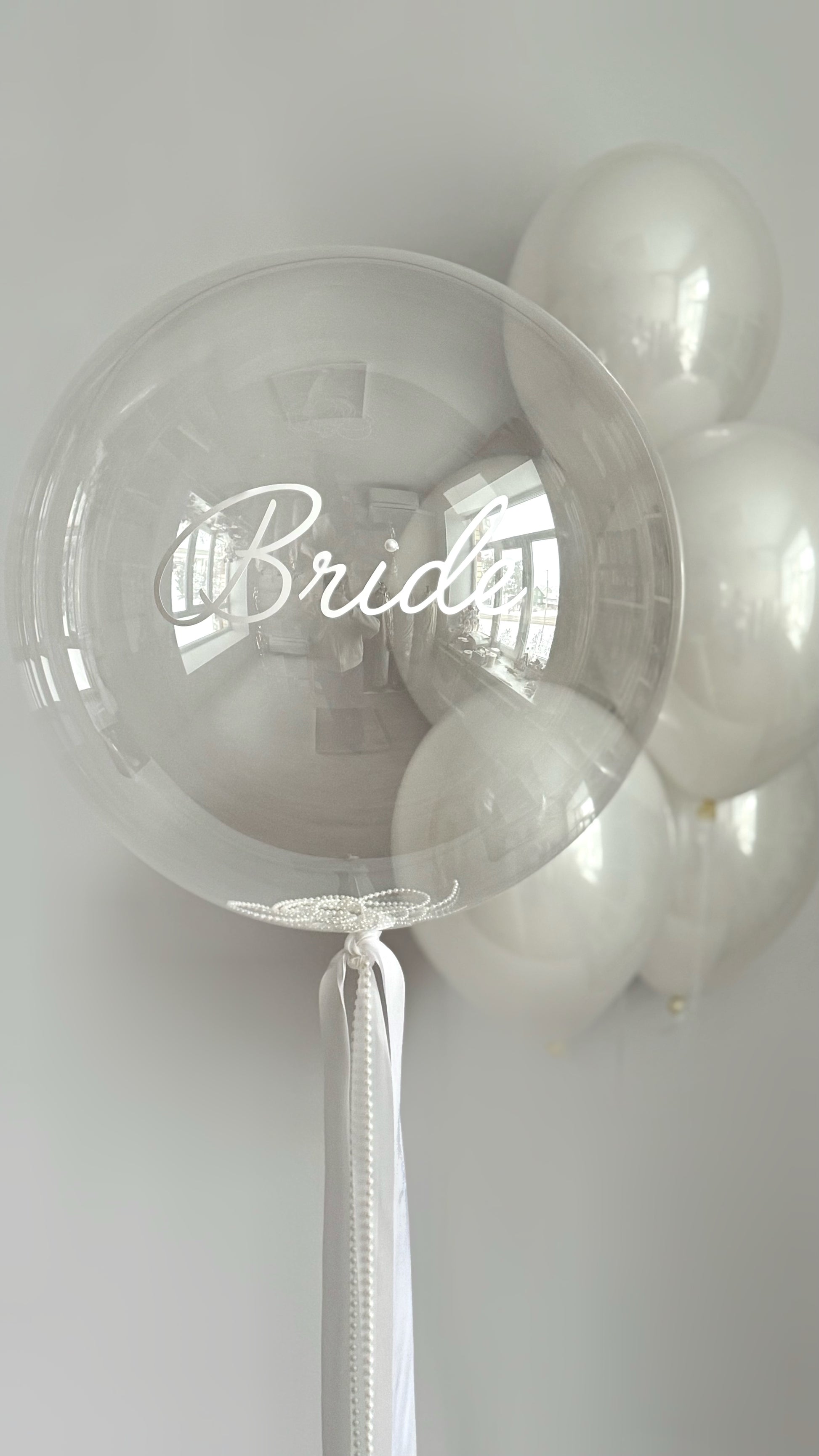 Clear bubble balloon with custom bridal sign and white side balloons for event decor in NYC