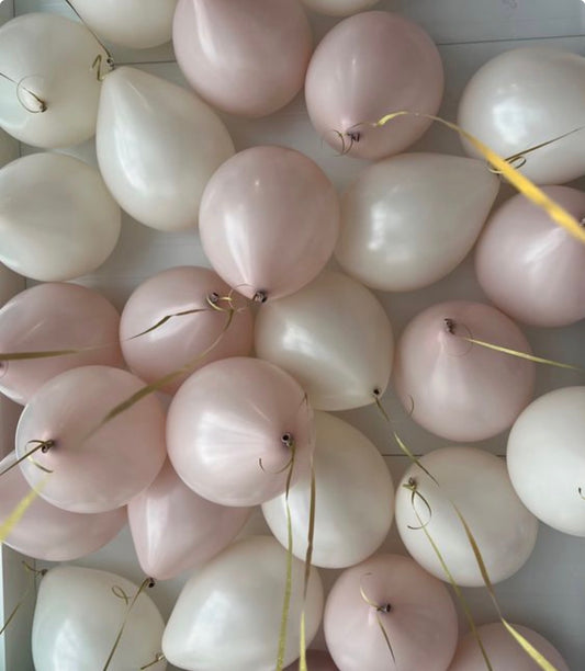 Soft pastel pink and cream helium balloons floating from the ceiling in New York City