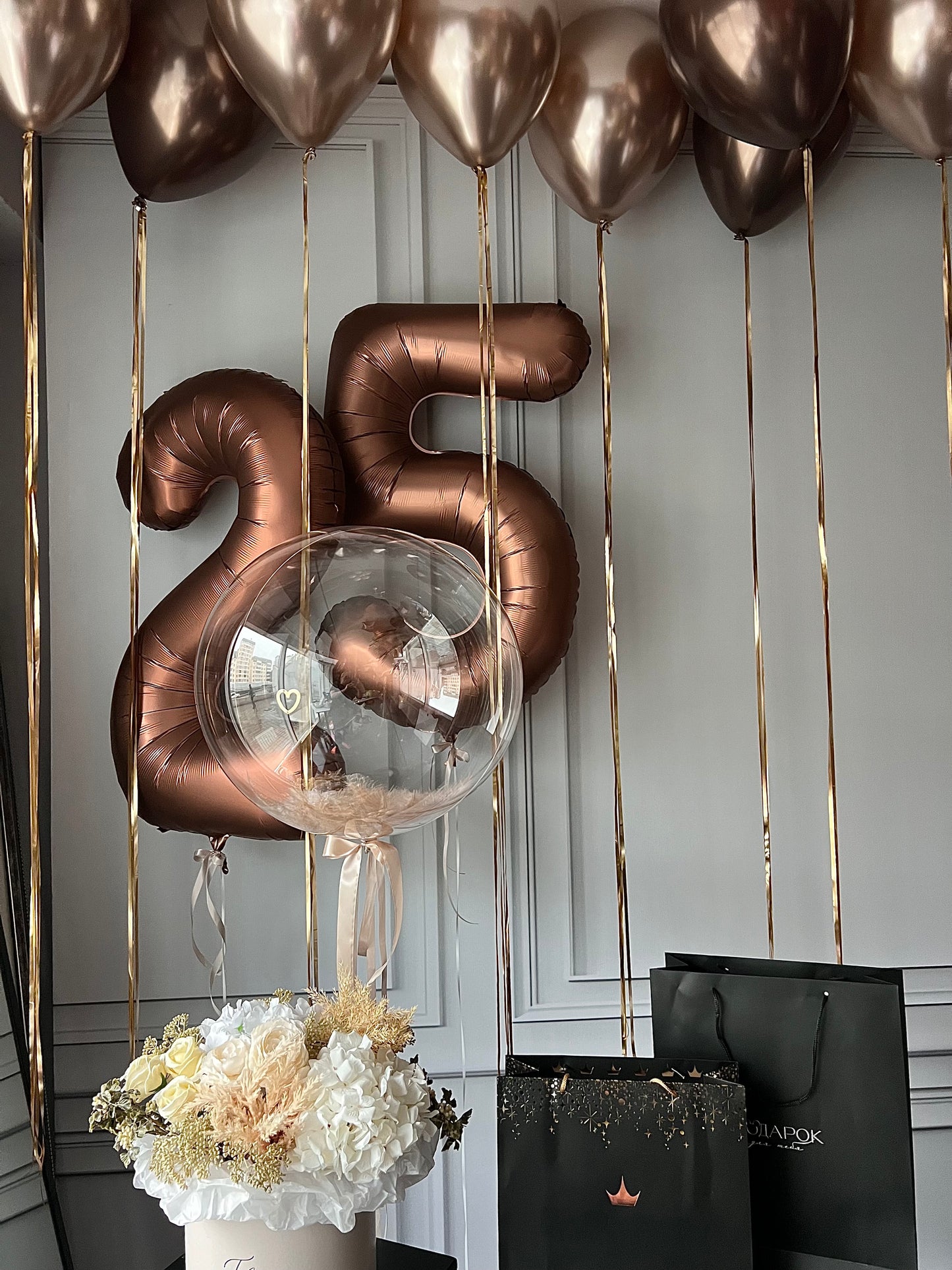 Aesthetica balloon set with feather bubble balloon, bronze number balloons, and ceiling balloon decor in New York