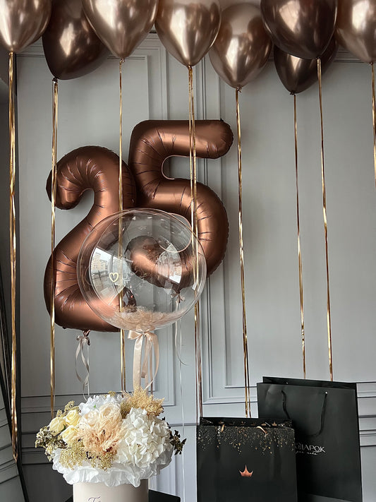 Aesthetica balloon set with feather bubble balloon, bronze number balloons, and ceiling balloon decor in New York