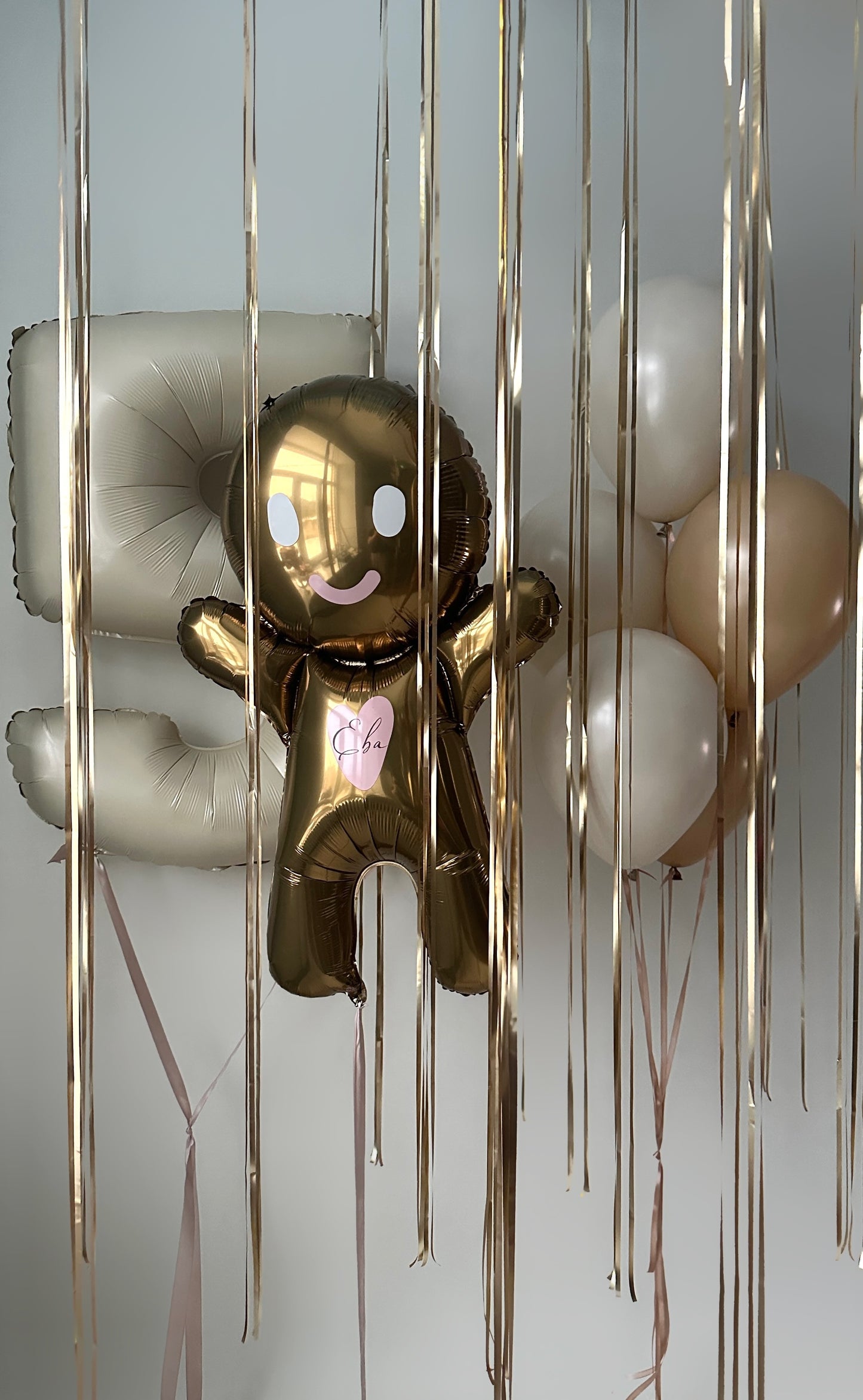 Close-up of gingerbread balloon and birthday balloon bouquet for kids party decor in Brooklyn