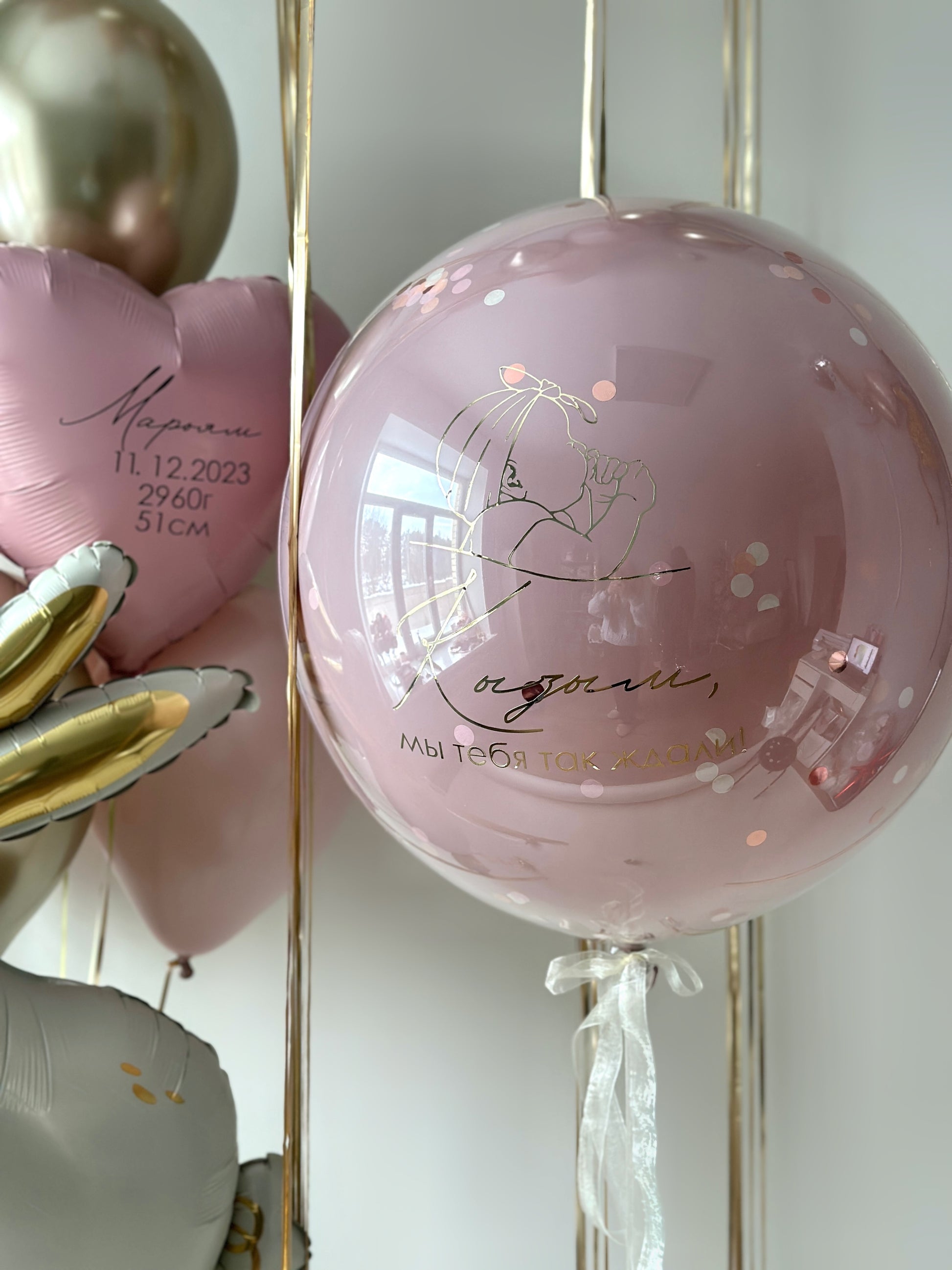 Close-up of personalized baby girl bubble balloon with soft pink and champagne balloons in Brooklyn