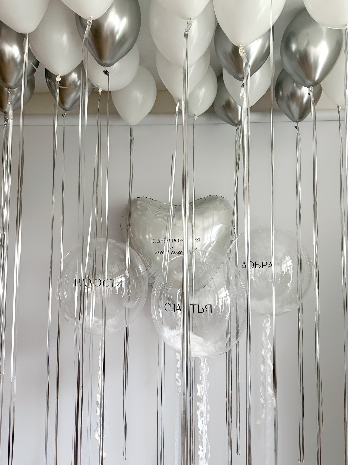 Birthday balloon set with clear bubble balloons, heart balloon, and white silver decor for celebration styling in New York