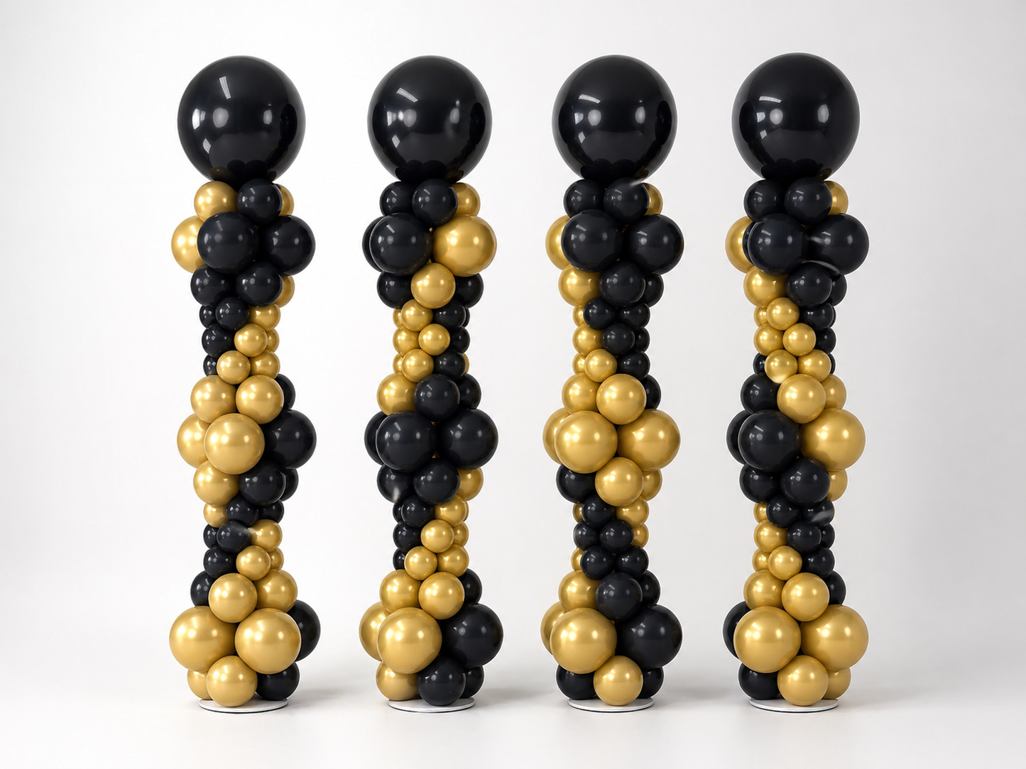 Black and gold graduation balloon columns with custom top balloons for a graduation event in Brooklyn
