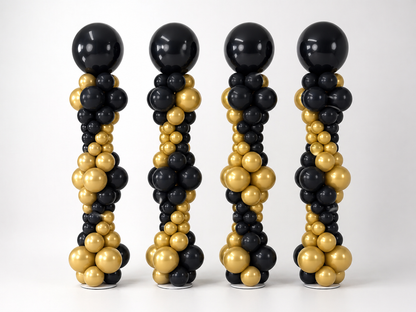 Black and gold graduation balloon columns with custom top balloons for a graduation event in Brooklyn
