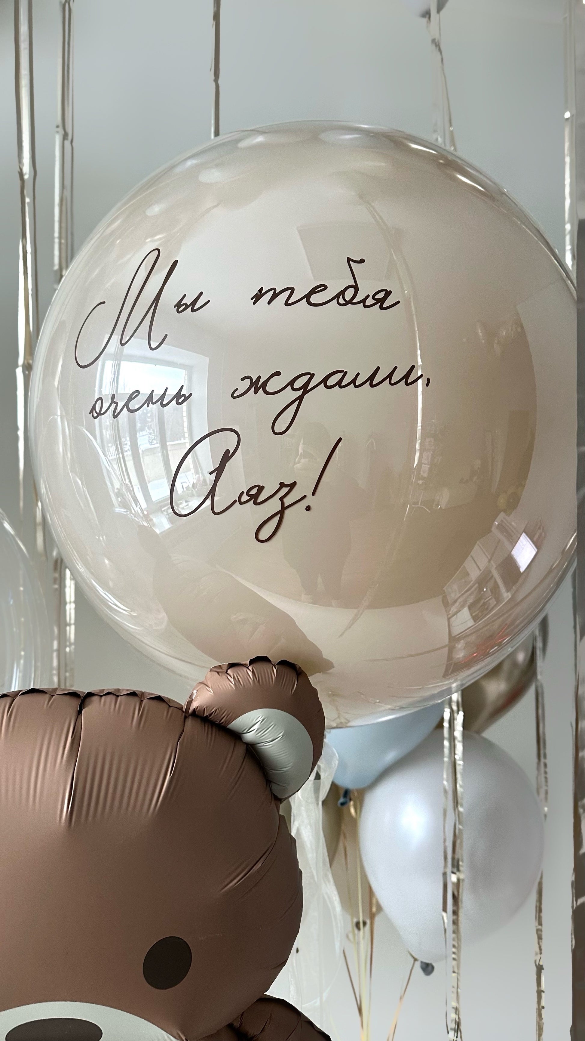 Custom sign bubble balloon with neutral baby welcome styling and feather detail in Queens