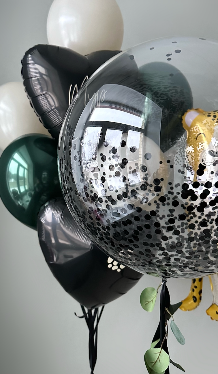 Close-up of jungle balloon decor with leopard foil balloon and custom confetti bubble balloon in Brooklyn