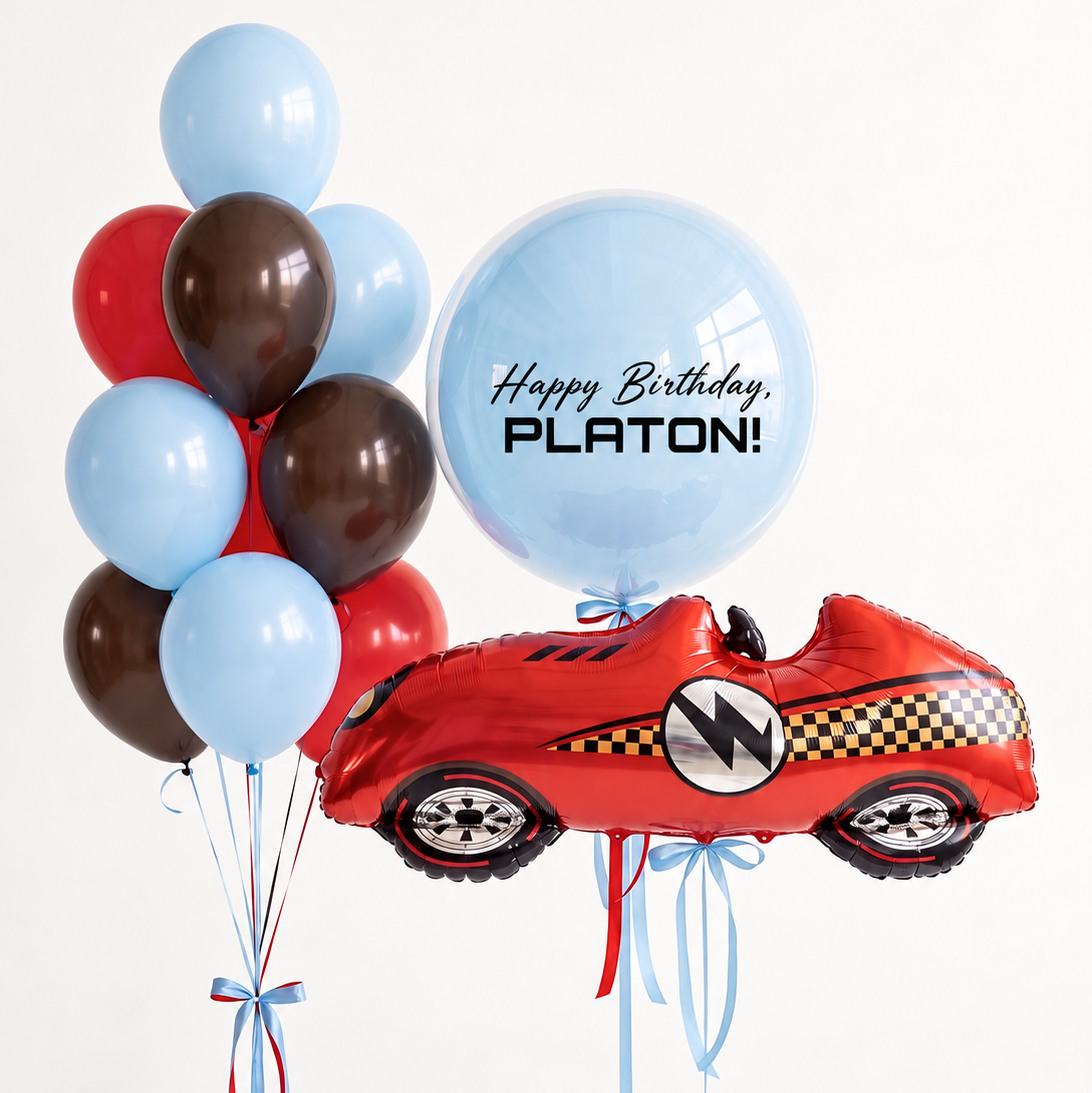 Red race car balloon with checkered details, a personalized light blue birthday bubble and a bunch of light blue, red and brown latex balloons.