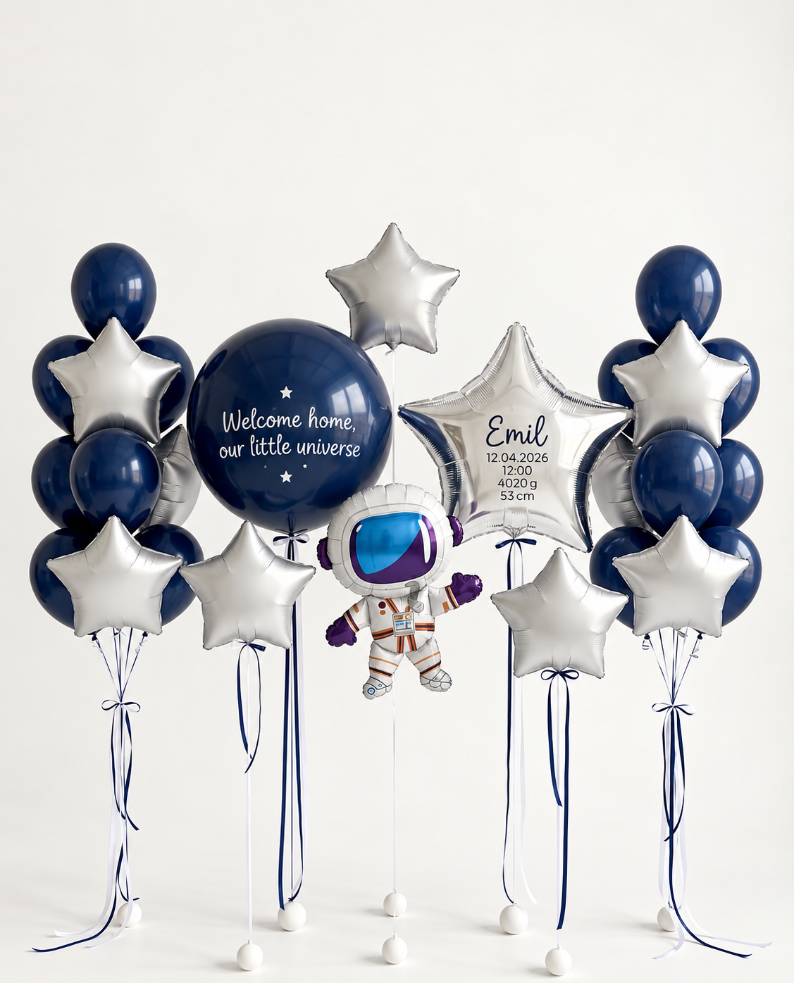 Navy and silver baby welcome balloon arrangement with a personalized bubble, a personalized silver star, an astronaut, three separate silver stars and two balloon bunches.