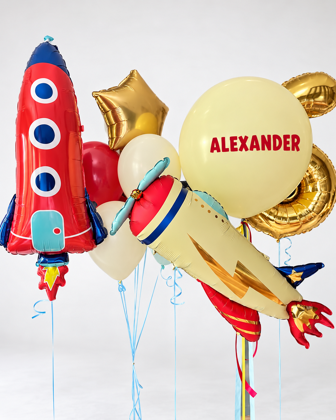 Red rocket and vintage airplane balloons with a personalized large yellow balloon, a gold number three and a bunch of latex balloons topped with a gold star.