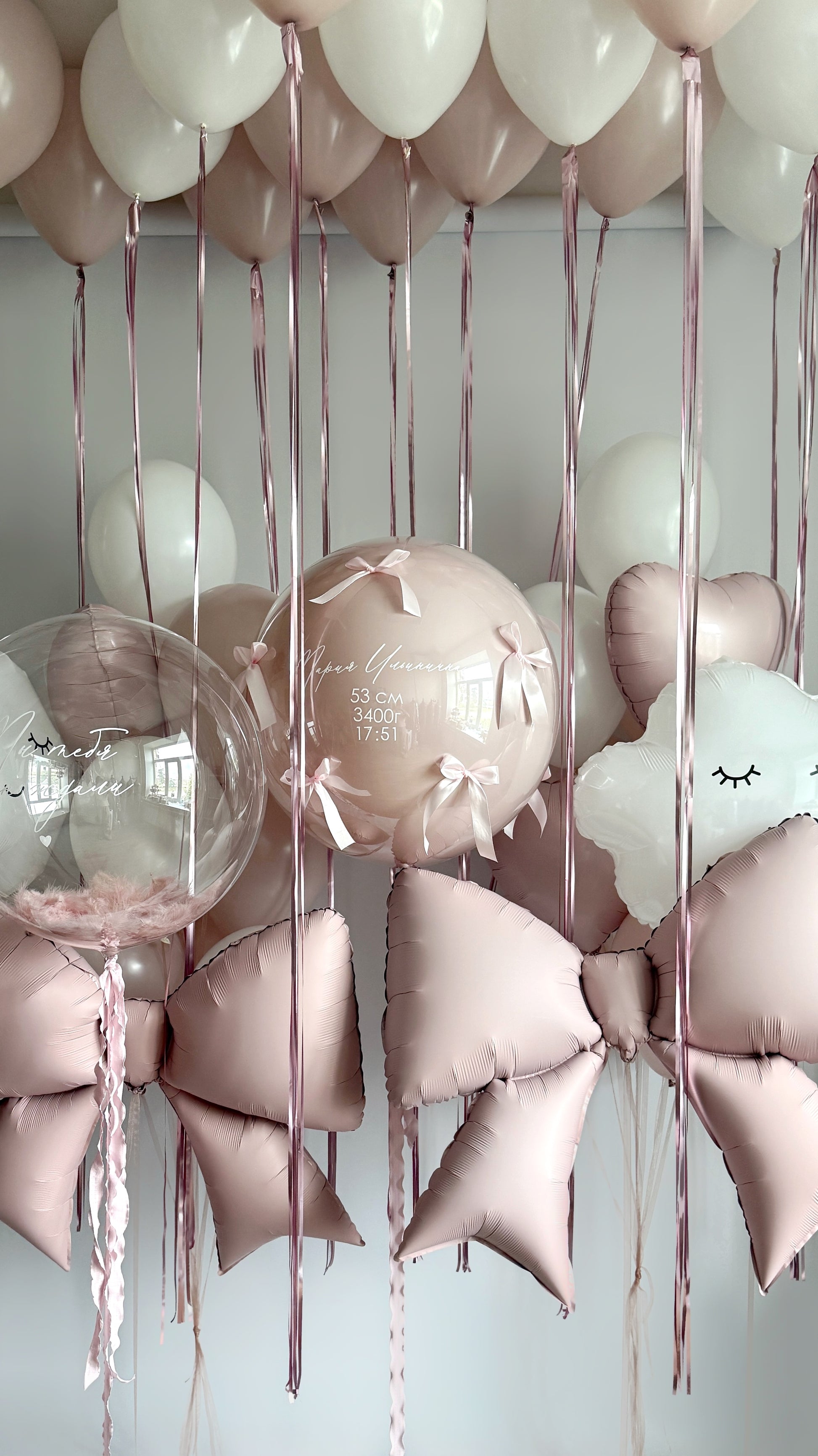 Newborn dreams balloon installation with custom sign bubble balloons, bows, and ceiling decor in New York