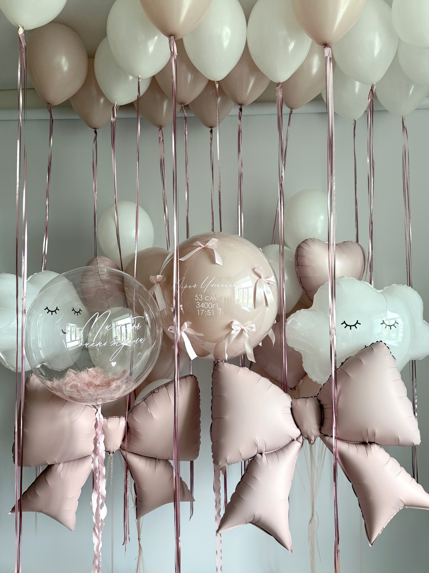 Luxury baby welcome balloon installation with bows, clouds, and ceiling balloons in Manhattan