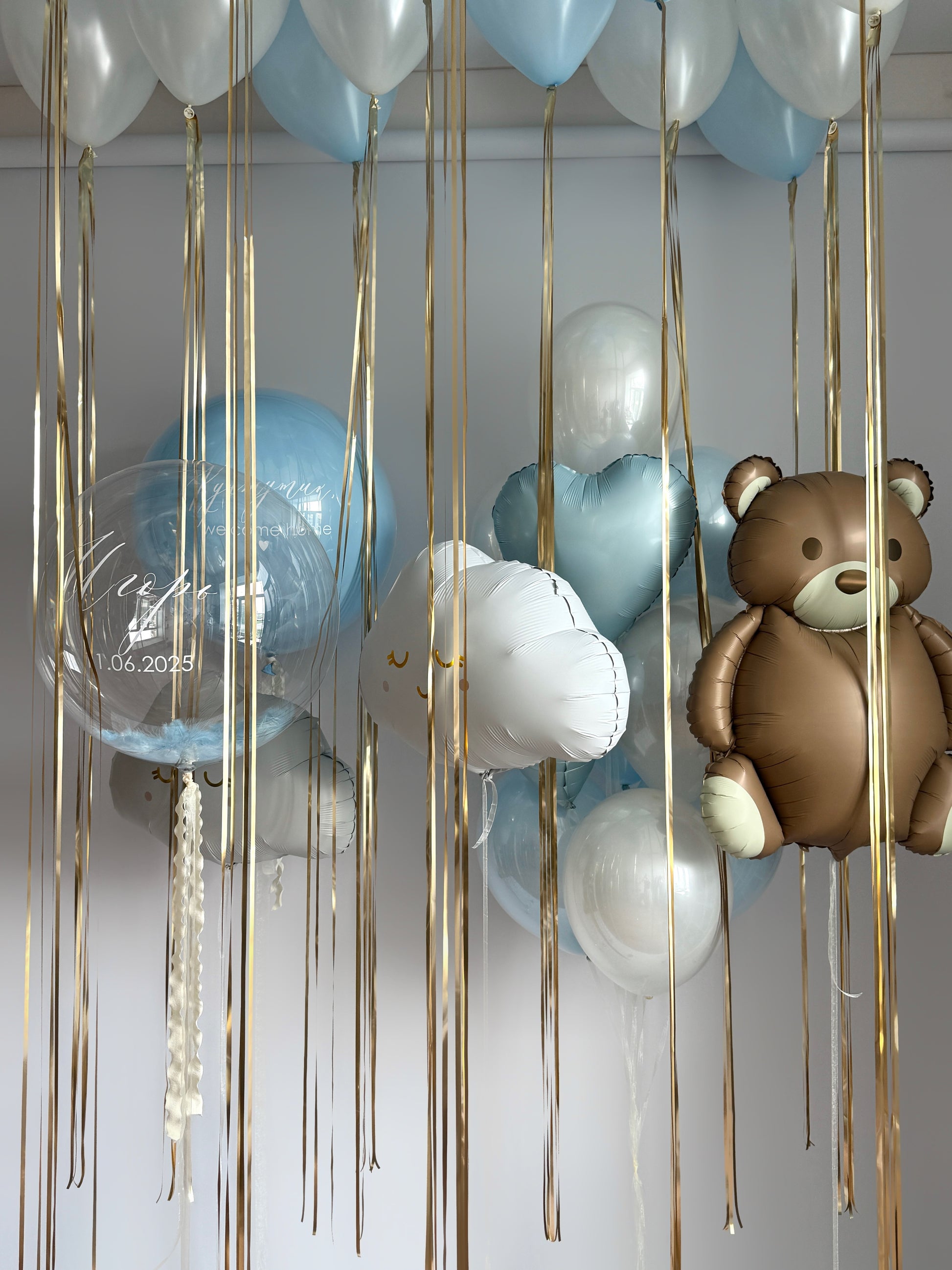Newborn welcome balloon installation with teddy bear balloon, cloud balloons, ceiling balloons, and custom sign bubble balloons in New York