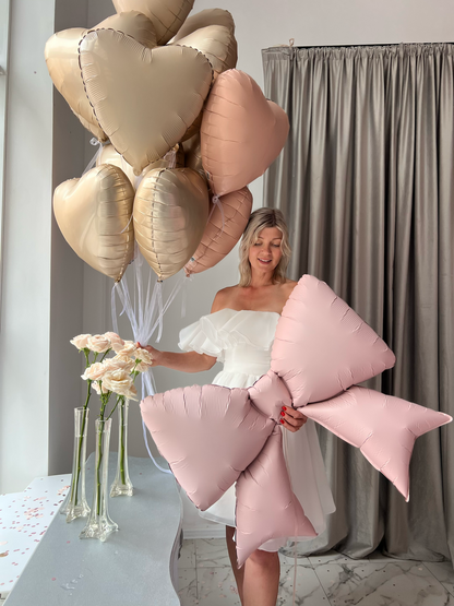 Close-up of pink bow balloon with heart balloons for bachelorette party decor in Brooklyn