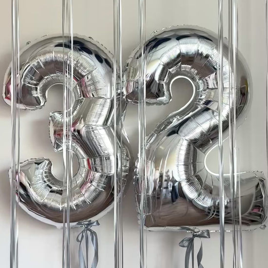 Video of silver number balloons with ceiling balloon setup for celebration decor in Brooklyn