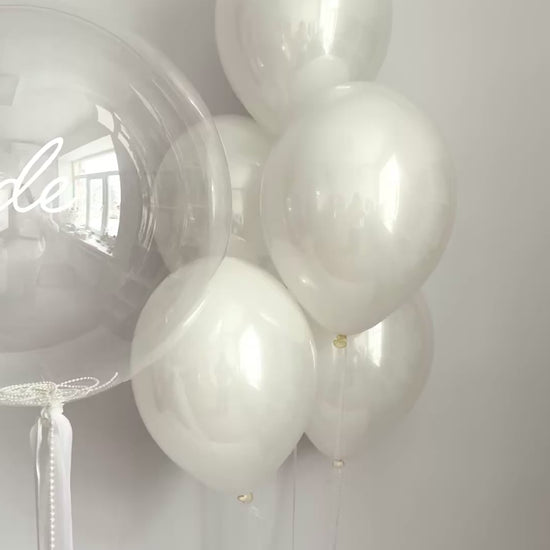 Clear bridal bubble balloon arrangement with white latex balloons for celebration decor in NYC
