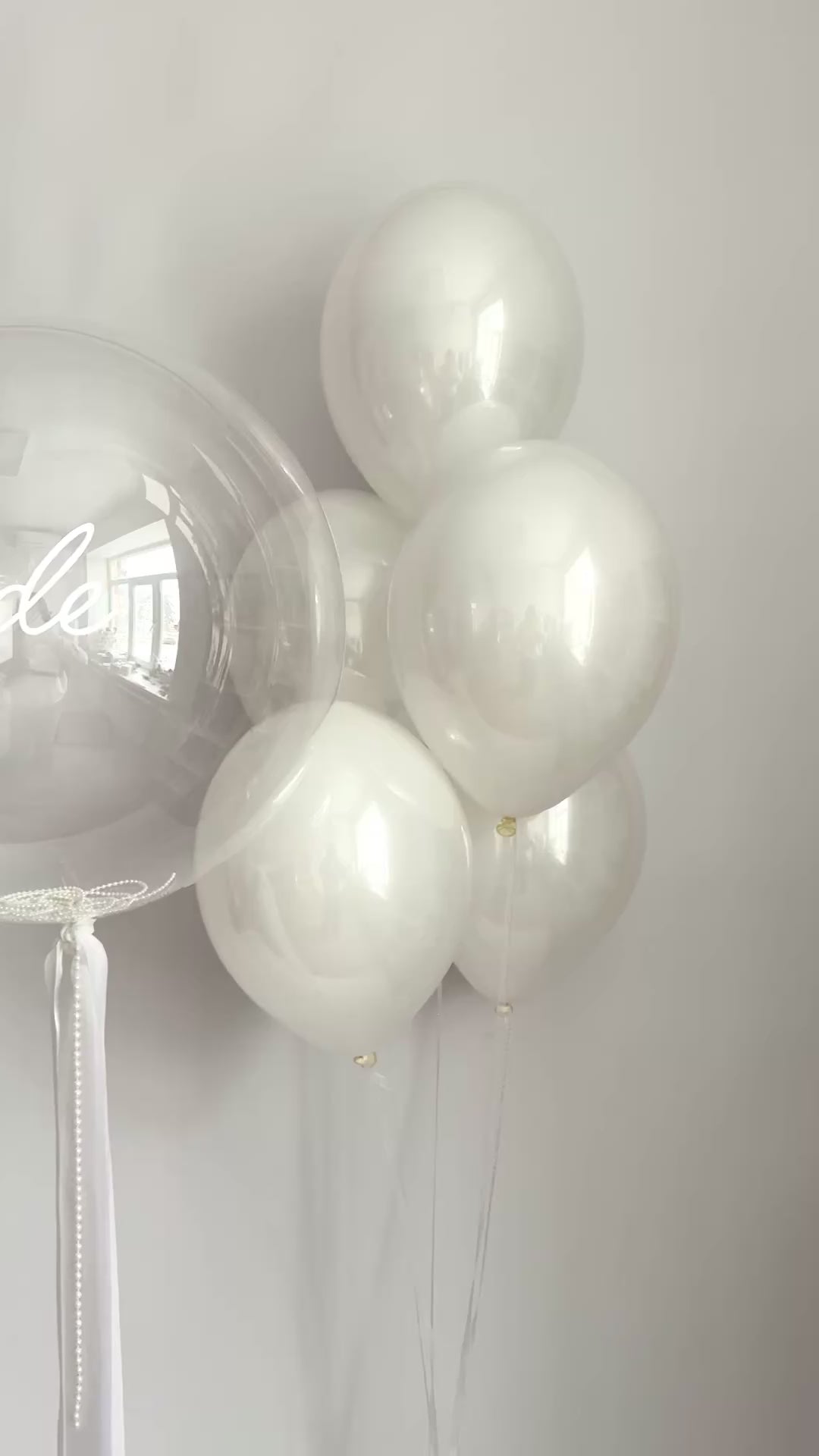 Clear bridal bubble balloon arrangement with white latex balloons for celebration decor in NYC
