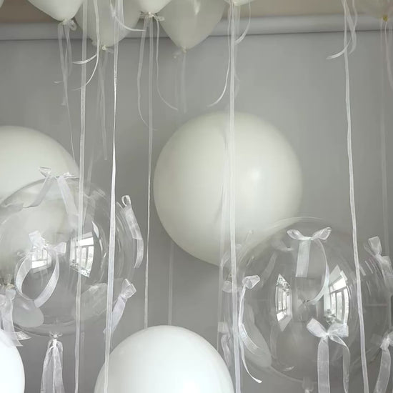 Video of clear and white balloon decor with oversized latex balloons and organza bows in Brooklyn