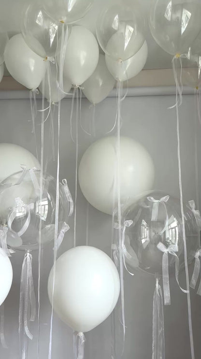 Video of clear and white balloon decor with oversized latex balloons and organza bows in Brooklyn
