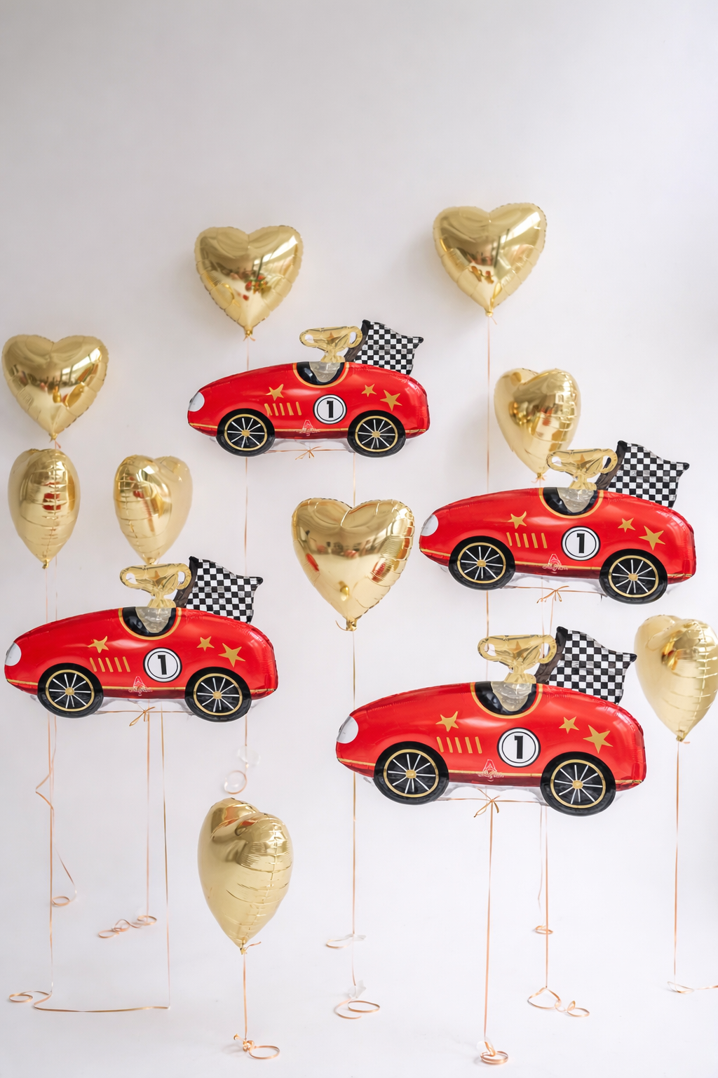 Racing balloon set with 4 red race car balloons and 9 gold heart balloons for themed party decor