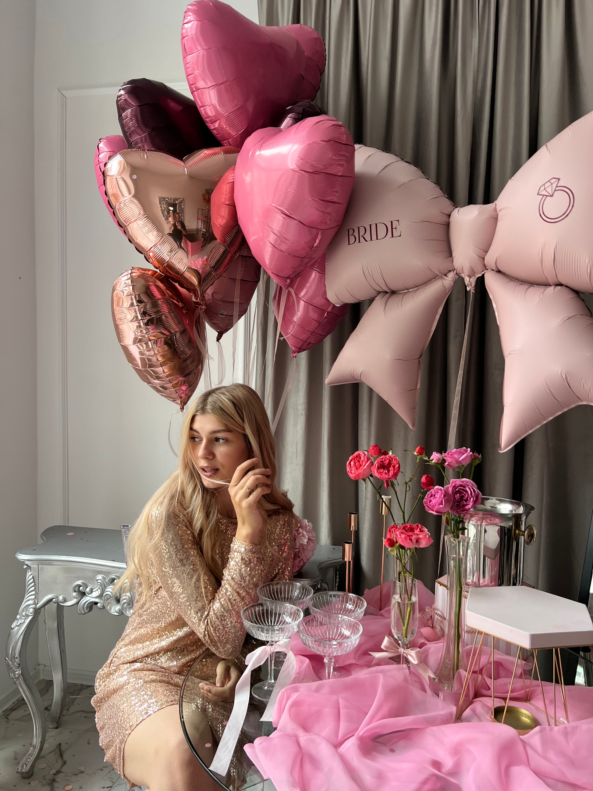 Close-up of raspberry bow balloon with custom sign and heart balloons for bachelorette party decor in Brooklyn
