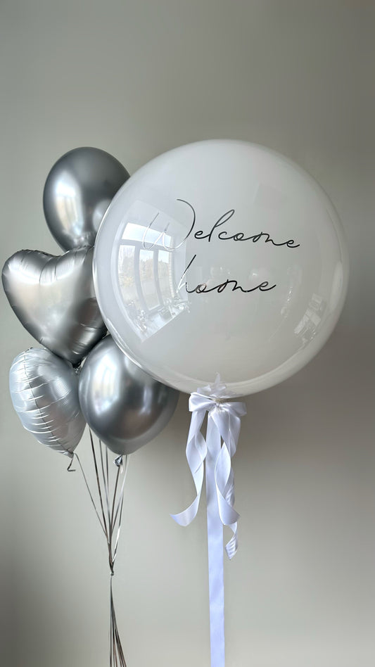Simple welcome balloon set with custom sign bubble balloon and silver heart balloons for baby celebration decor in New York