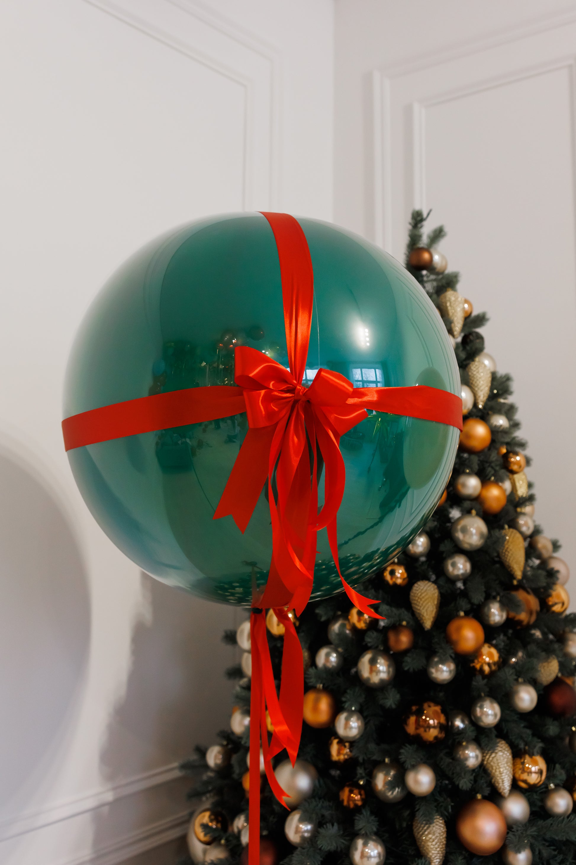 The gift bubble balloon with red bow and festive green design for holiday decor in New York