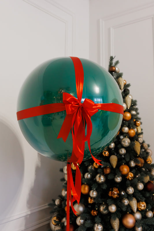The gift bubble balloon with red bow and festive green design for holiday decor in New York