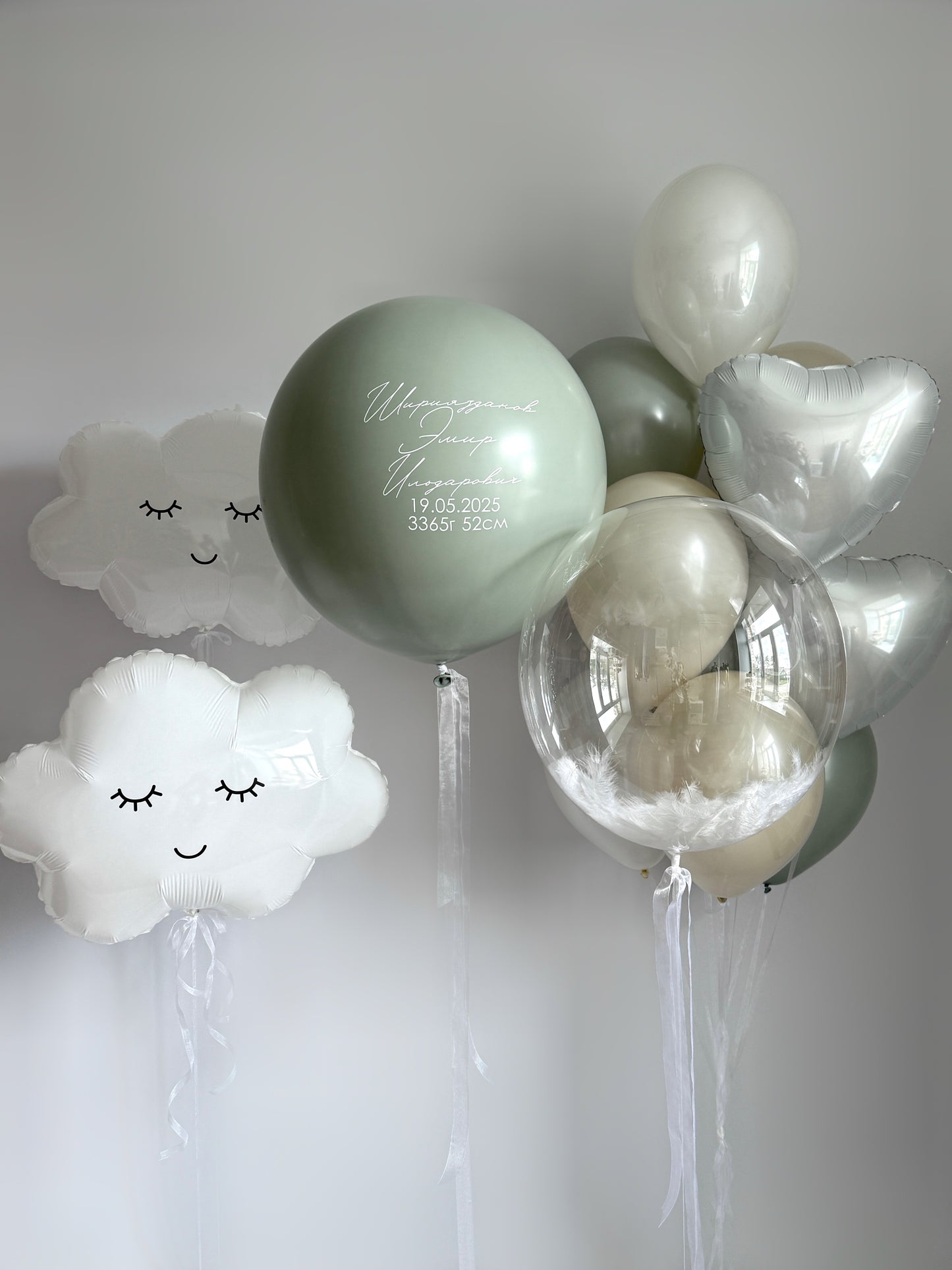 Under the trees balloon set with cloud balloons, feather bubble balloon, and custom sign for baby celebration decor in New York