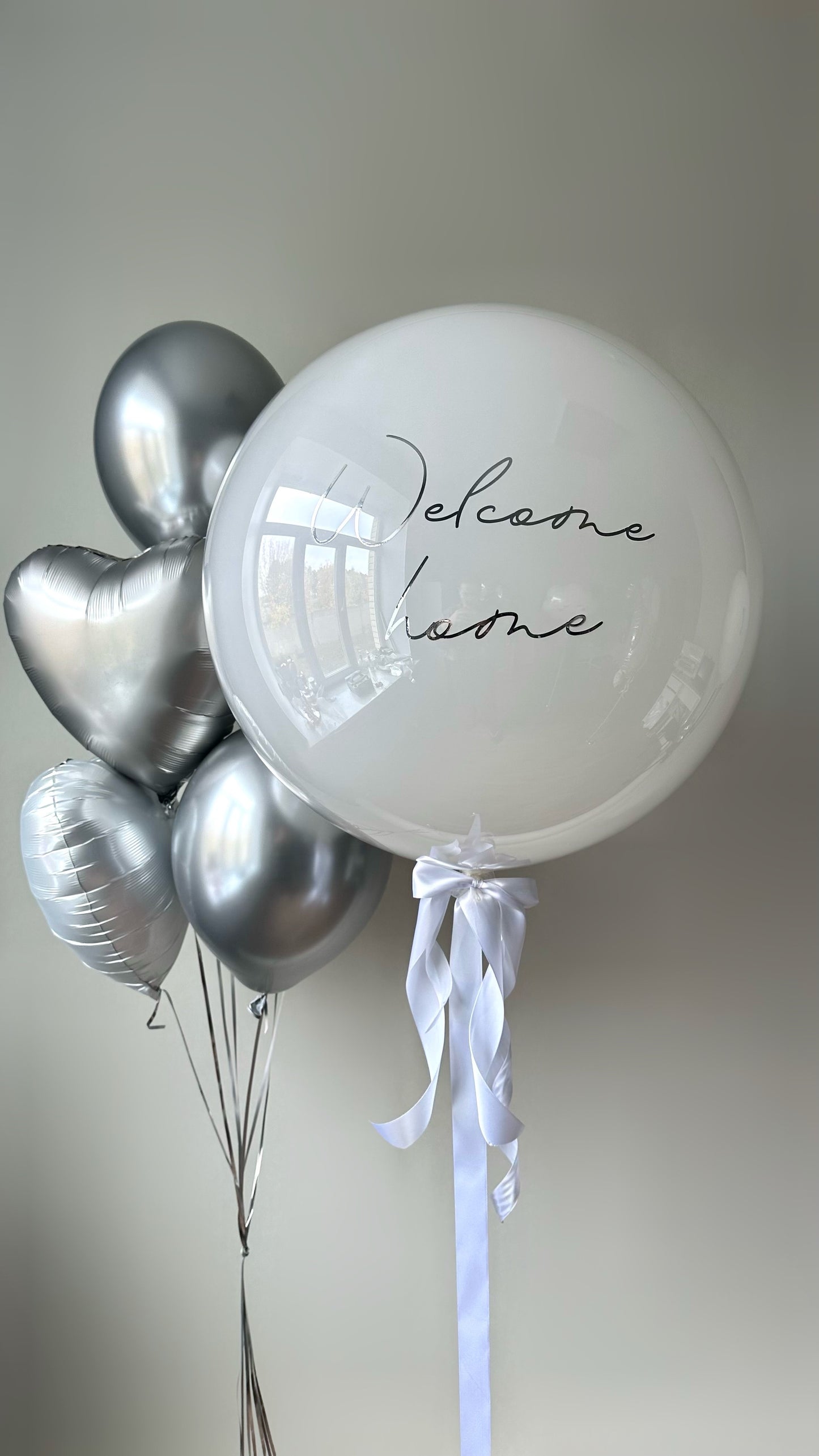 Warm welcome balloon set with custom sign bubble balloon and silver heart balloons for baby celebration decor in New York