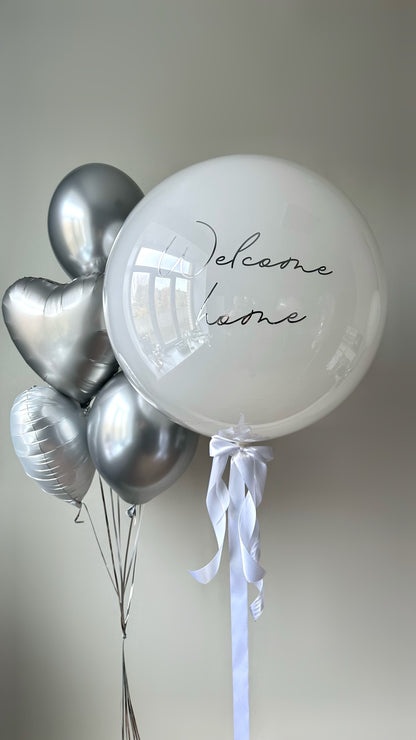 Warm welcome balloon set with custom sign bubble balloon and silver heart balloons for baby celebration decor in New York